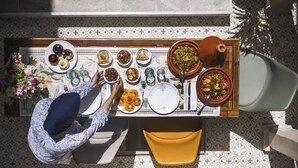A dining table with various dishes and a person serving food. - Riad Bab Aljana (Marrakech)