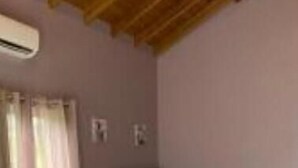 A bedroom with a bed, a sofa, a nightstand, and a window with curtains. - Modern spacious accommodation 1 (Cedar Grove)