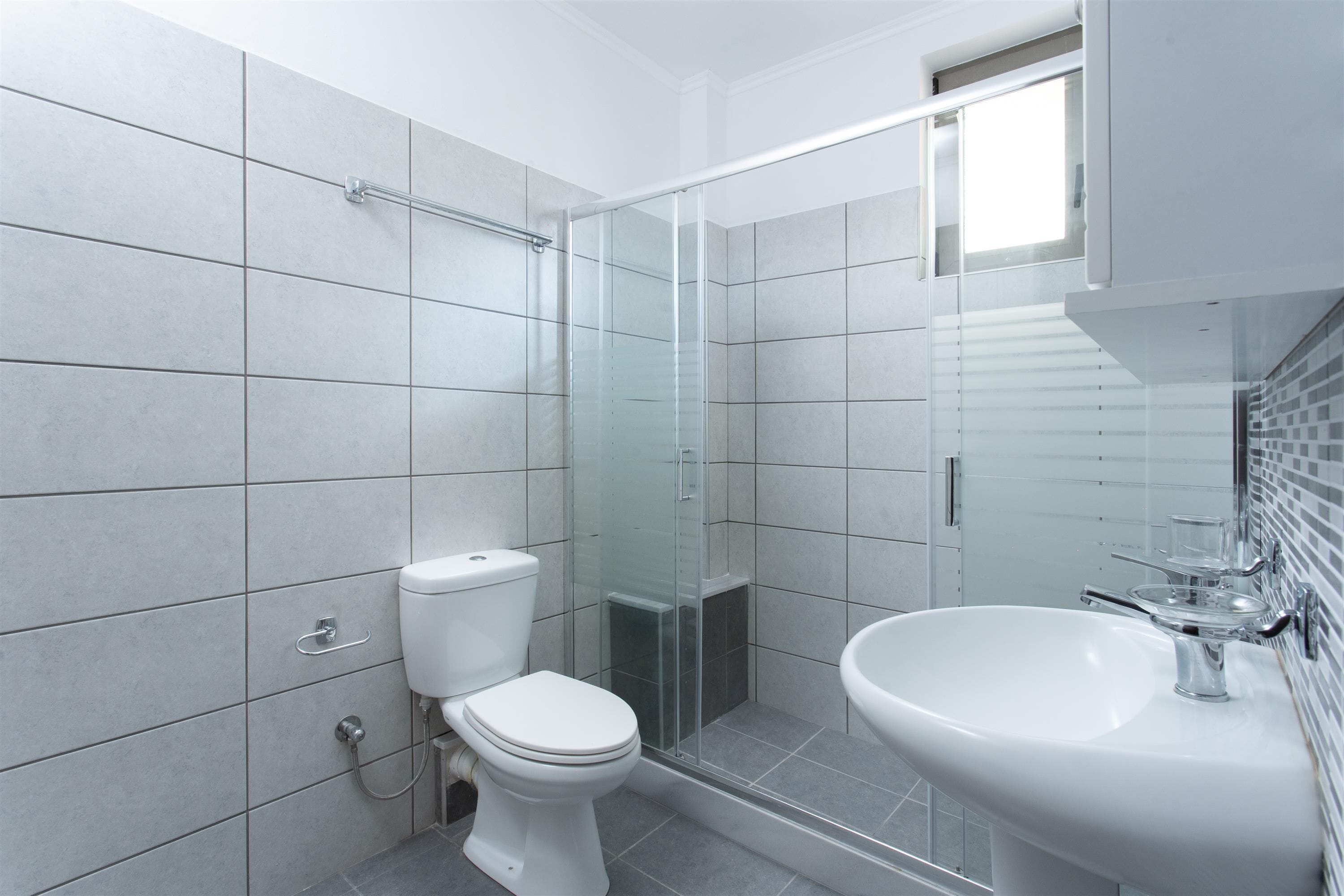 Ein modernes Badezimmer mit Toilette, Dusche und Waschbecken.