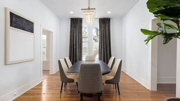 Un comedor con una mesa rectangular, seis sillas y una araña.