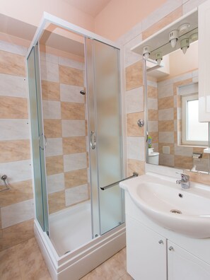 Estudio clásico, 1 cama de matrimonio grande, no fumadores, vistas parciales al mar | Baño | Ducha, secador de pelo, toallas y jabón