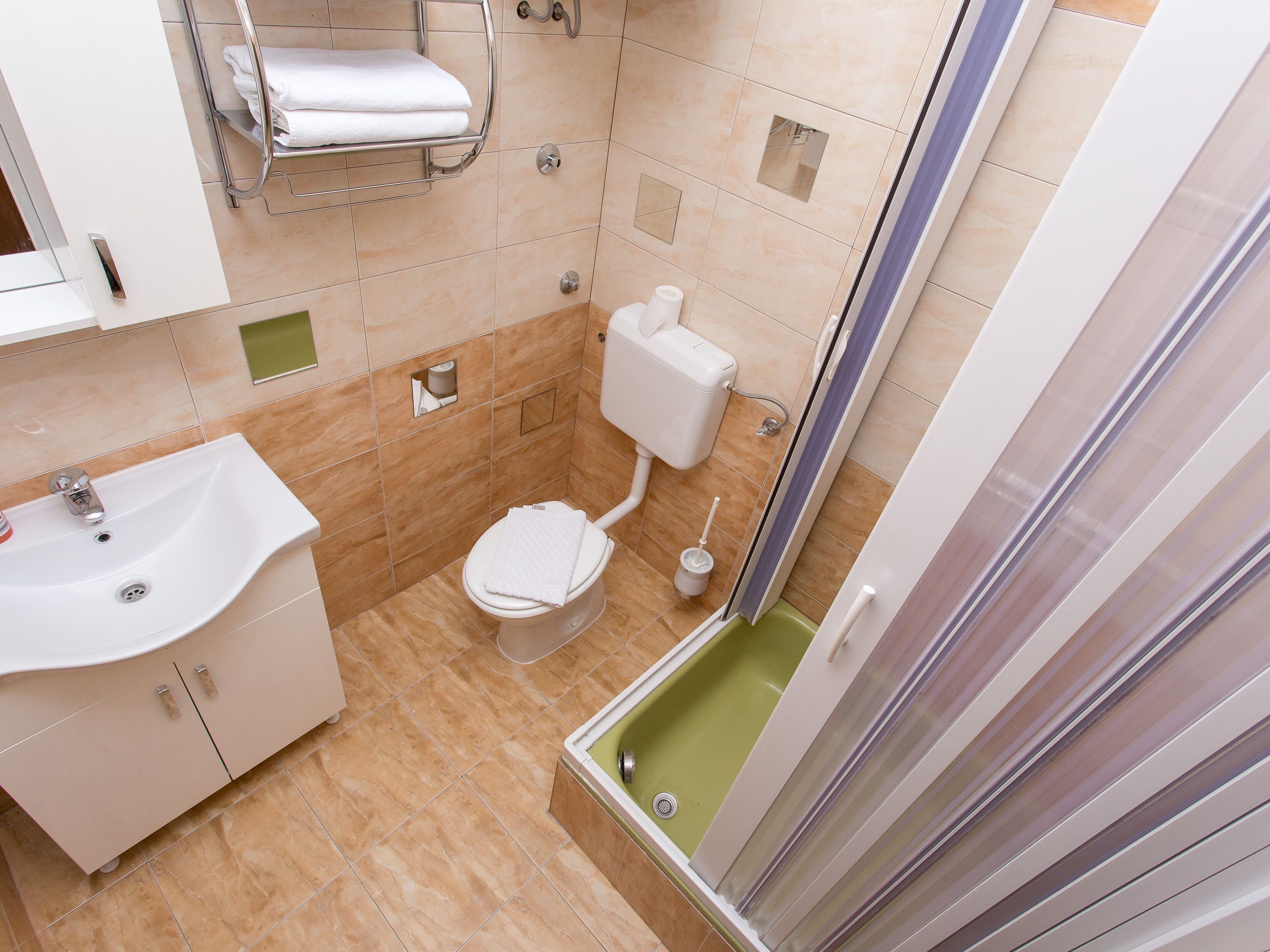 Une salle de bain comprenant un lavabo, des toilettes et un espace douche.