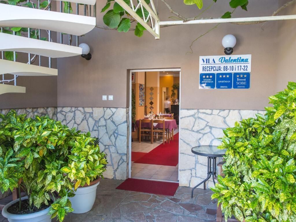 A reception area with a sign indicating Valentina as the receptionist, available from 08:10 to 17:22.