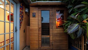 Una pequeña estructura de madera con una puerta, una ventana y un pequeño panel de control en la pared.