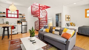 Un apartamento moderno con una escalera de caracol, cocina, sala de estar con sofá y comedor.