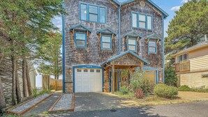 A two-story house with a garage, a front porch, and a small garden area. - Infinity View - Ocean Front (Lincoln City)