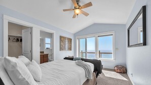 A bedroom with a bed, a ceiling fan, a large window with a view, and a closet. - Infinity View - Ocean Front (Lincoln City)