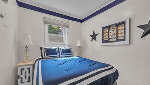 Una camera da letto con un letto, due comodini, una finestra e decorazioni alle pareti.