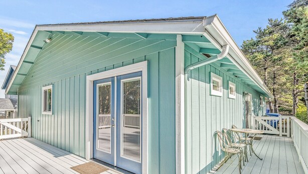 A house with a porch, a door with a window, and a small deck area. - Surf Song - Walk to the Beach (Lincoln City)