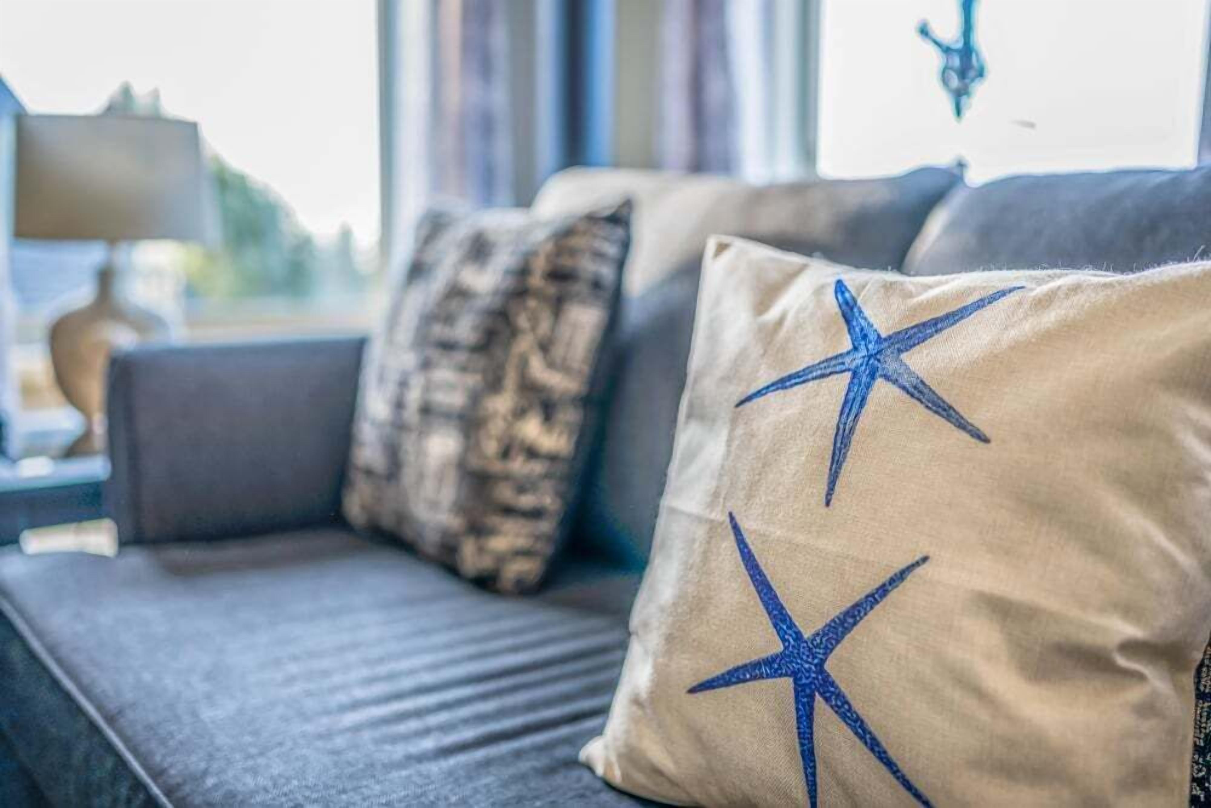 Un sofá con dos almohadones, uno con diseño de estrella.