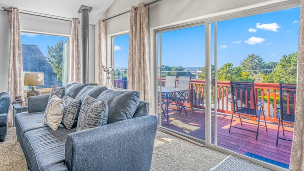 A balcony with a sofa and chairs, large sliding glass doors, and a view of the outdoors. - The Flip Flop Inn - Walk to the Beach (Lincoln City)