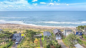 Uma área residencial costeira com casas, uma praia e céu claro.