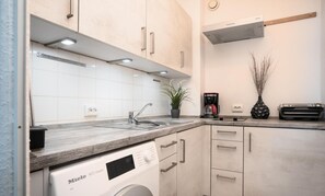 Fridge, coffee/tea maker, cookware/dishes/utensils, dining tables