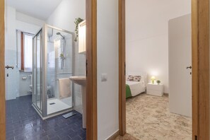 Ein modernes Badezimmer mit Duschkabine aus Glas, einem weißen Waschbecken und einer Toilette.