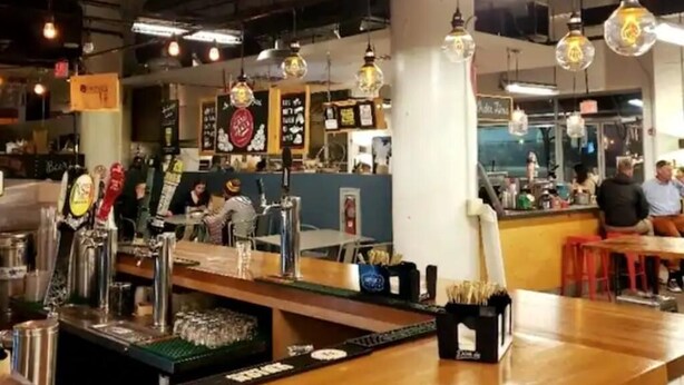 A bar area with multiple beer taps, a counter, and stools. - Sun-Drenched Apartment in City Unit B (Baltimore)