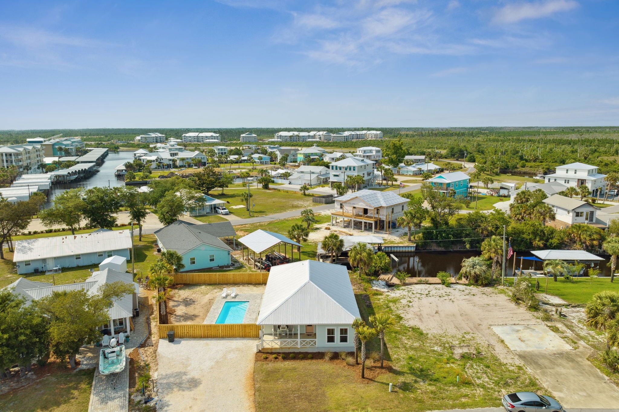 Un quartier résidentiel avec des maisons, une piscine et un quai.