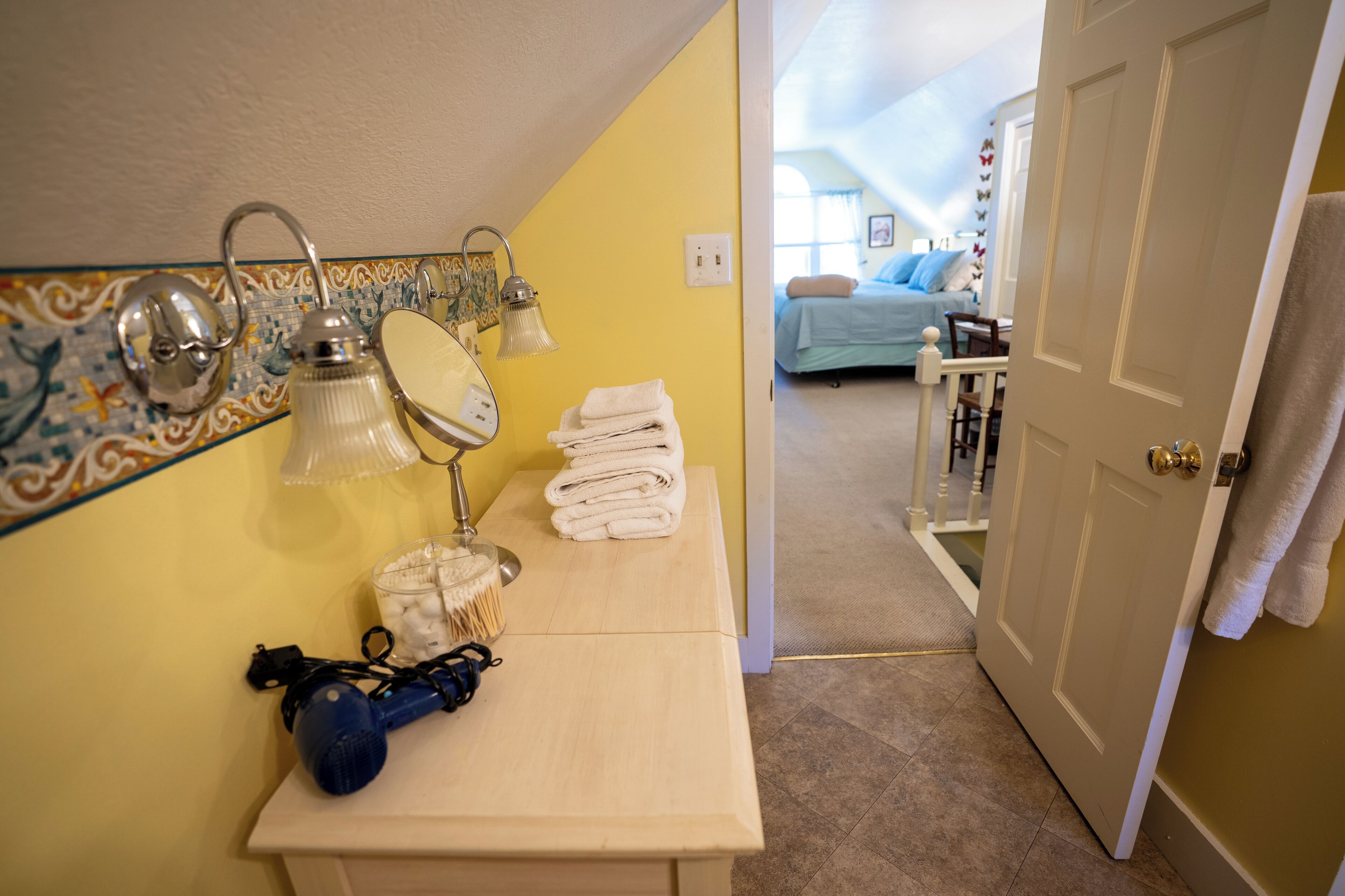 A bathroom with a sink, mirror, and towel rack.