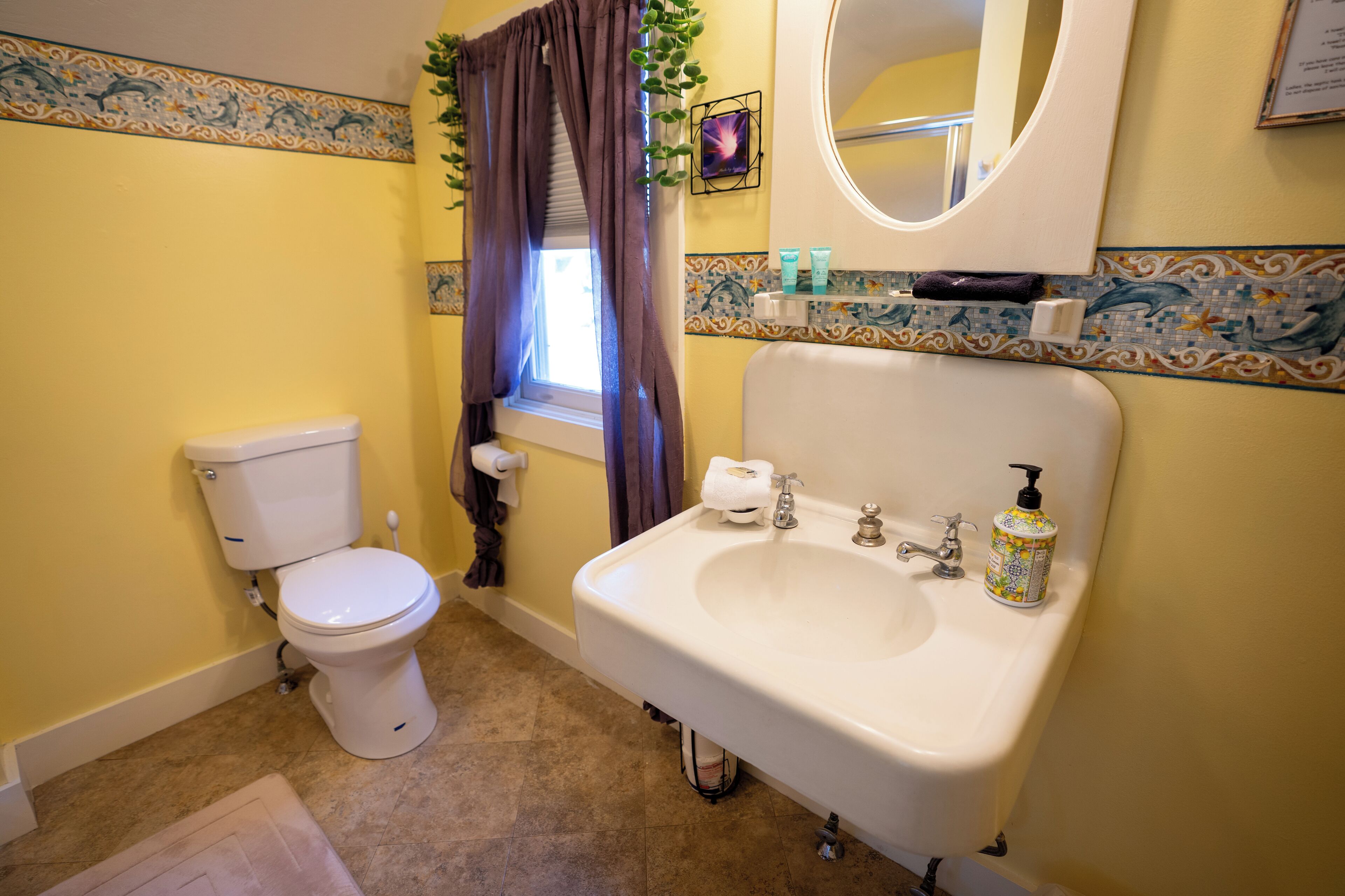 A bathroom with a toilet, sink, and mirror.