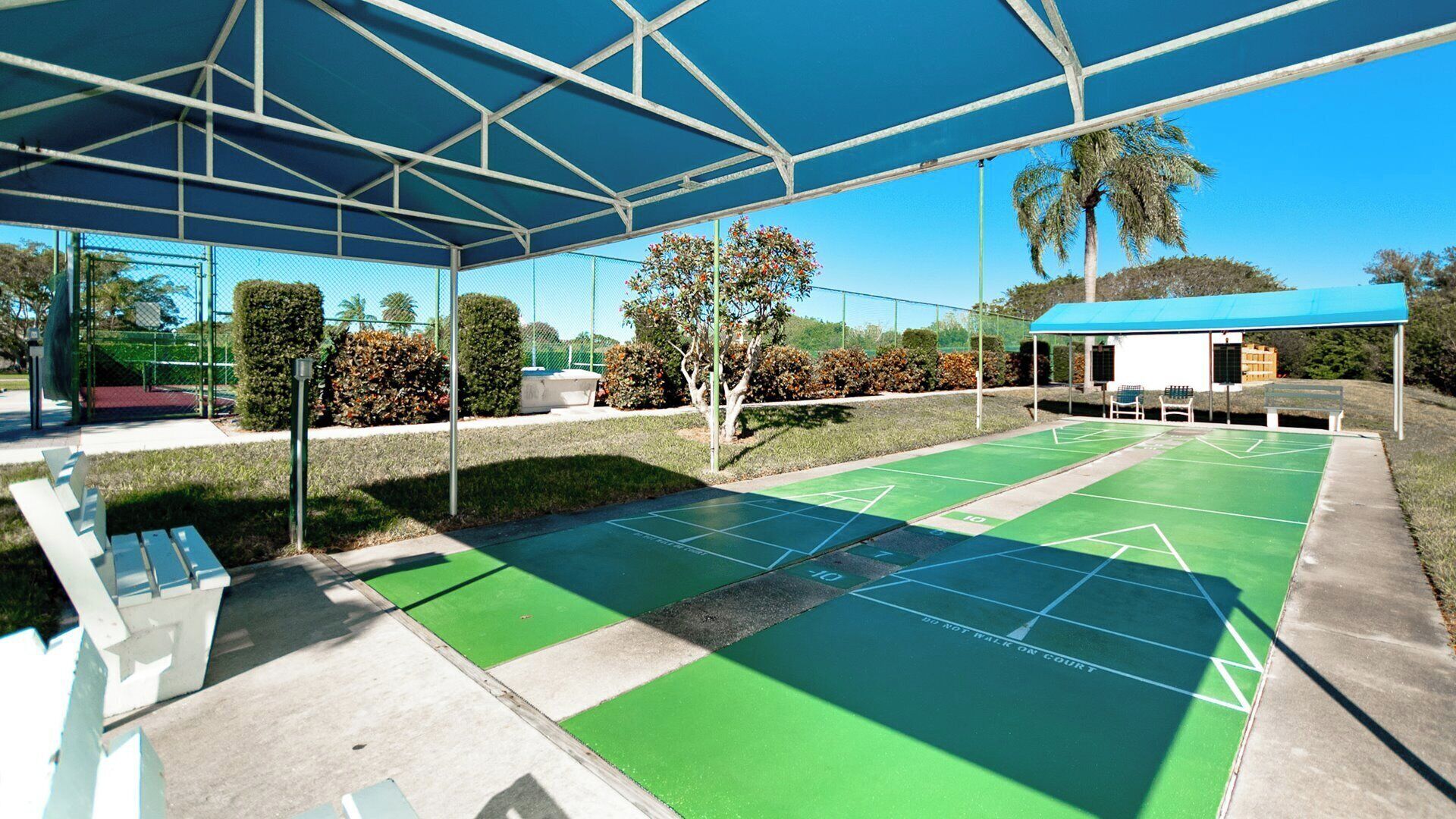 Un’area esterna coperta con un campo da shuffleboard, panchine e un piccolo riparo.