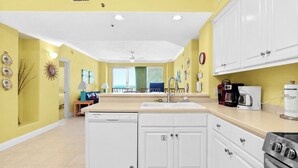 Una cocina moderna con alacenas blancas, lavavajillas, pileta y estufa.