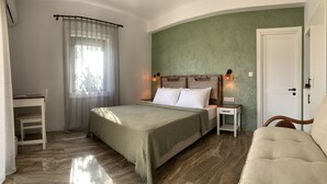 A bedroom with a bed, bedside tables, a chair, and a door. - Zeytinlibahçe Konukevi (Bozcaada)