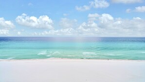 A beach with clear turquoise water and a white sandy shore.