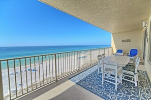 A balcony with a view of the beach and ocean.