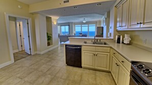 A spacious kitchen with a dishwasher, oven, and a large island. - Gulf Crest 2006- 20th Floor Living w/ Beach Service (Panama City Beach)
