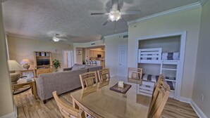 A spacious living area with a dining table, chairs, a sofa, and a ceiling fan. - Gulf Crest 2006- 20th Floor Living w/ Beach Service (Panama City Beach)