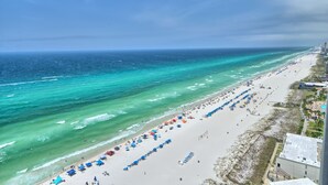 A beach with clear turquoise waters, a long stretch of sand, and numerous umbrellas. - Gulf Crest 2006- 20th Floor Living w/ Beach Service (Panama City Beach)
