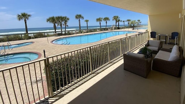 A pool area with multiple swimming pools, a beach view, and outdoor seating. - Gulf-Front Escape | 1st Floor + 2BR (Panama City Beach)