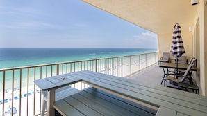 A balcony with a view of the beach and ocean.