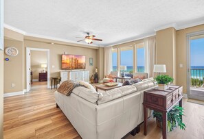 A living room with a sofa, coffee table, and a view of the ocean.