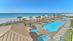 A resort with a large swimming pool, a separate hot tub, and a beach area with palm trees. - Gulf Crest 301 – 3BR Haven with 360° Views of PCB! (Panama City Beach)