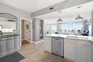 A spacious kitchen with white cabinetry, a dishwasher, and pendant lighting. - Relax at Gulf Crest: 2-Bedroom Condo Bella! (Panama City Beach)