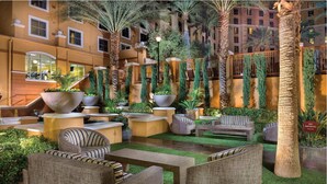 A well-lit outdoor lounge area with seating, planters, and palm trees. - 3Bed/2Bath Vegas Paradise at Grand Desert!! (Las Vegas)