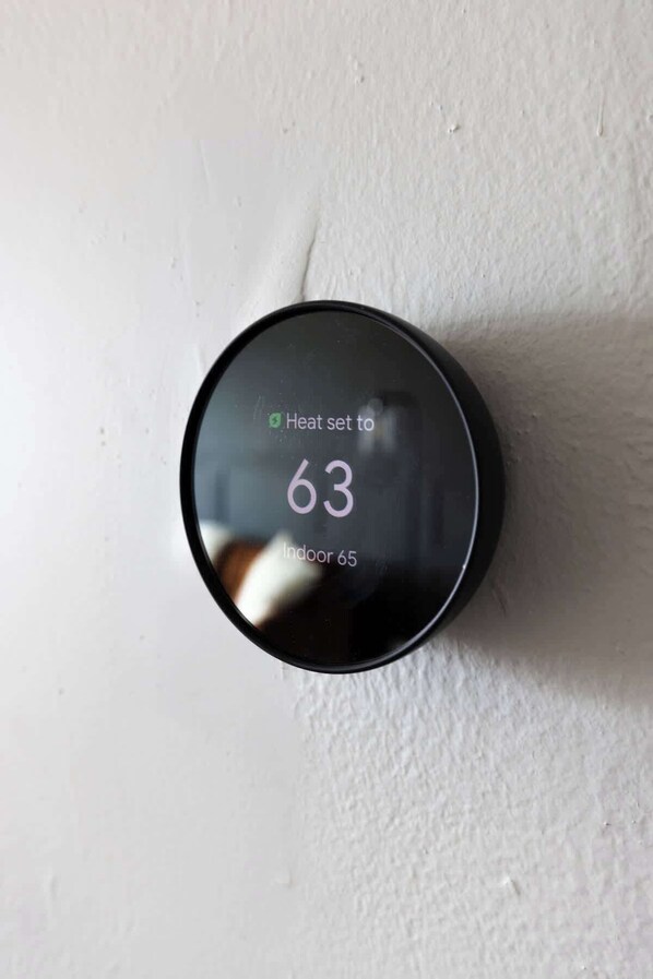 Un thermostat réglé sur une température de chauffage de 63 et affichant une température intérieure de 65.