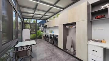 Een moderne keuken met inbouwapparatuur, een eethoek en uitzicht op het groen.