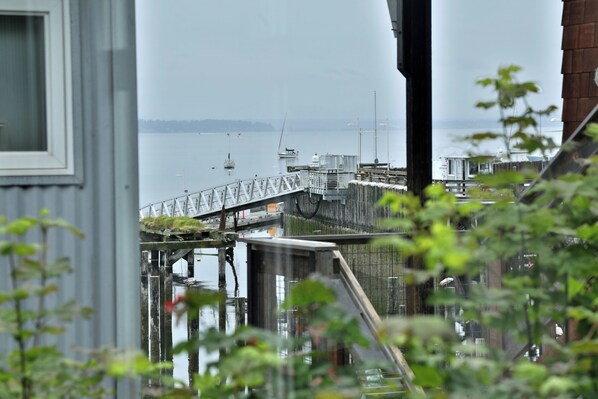A pier extending into calm water with boats, a wooden structure, and a metal fence. - Two-story townhouse just steps from the waters edge with a private deck. Perfect accommodations for families. Recently remodeled. Beautifully appointed (Langley)