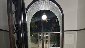 An entrance with a metal gate, a doormat with "EDIFICIO LEBLON" text, and a light fixture above the gate. - Studio Edifício Leblon (Leblon Rio de Janeiro)
