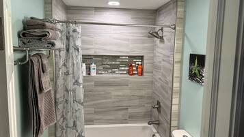 Chuveiro, toalhas de banho, sabonete, shampoo