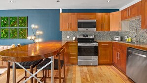 Una cocina moderna con armarios de madera, horno de acero inoxidable y salpicadero de azulejos.