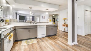 Una cucina moderna con isola centrale, elettrodomestici integrati e pavimento in legno.