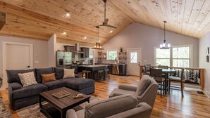 A spacious living area with a kitchen, dining area, and a large window providing natural light.