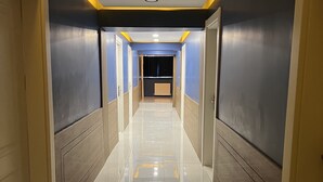 Un corridoio con pavimento piastrellato lucido, pareti dipinte in due tonalità e illuminazione a incasso.