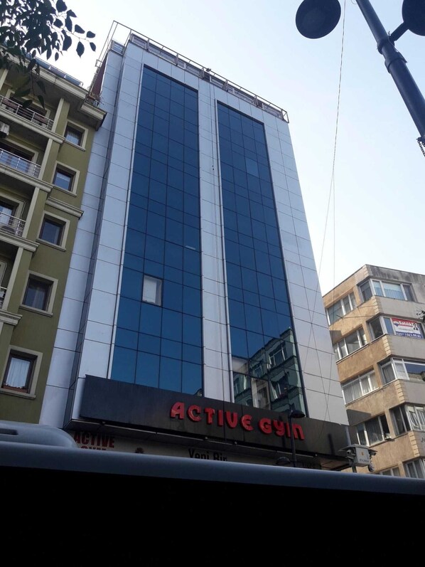 A modern building with a large glass facade and a sign for "ACTIVE gym" below. - The Blue Suites (Istanbul)