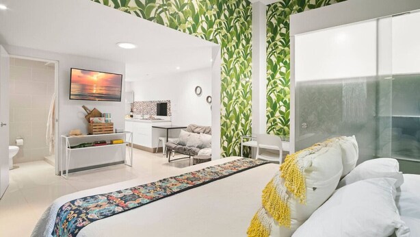 A bedroom with a bed, a desk, a chair, and a TV. - Studio across the street from beach, top location (Playa Langosta)