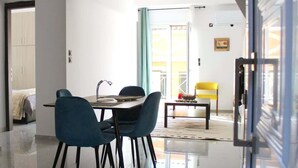 A modern living room with a dining area, a sofa, and a coffee table. - Central Old Town Stay - Bright & Fully Equipped (Patras)
