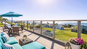 A deck with outdoor furniture, a table, and a view of the sea. - Bodega Bay Oasis  - Wine Tastings Included (Bodega Bay)