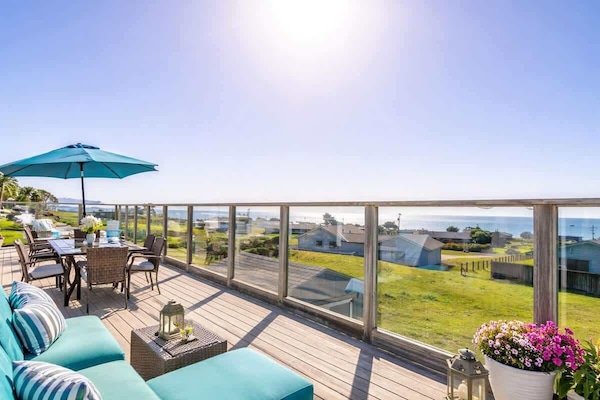 Sun-drenched deck with panoramic water views and cozy seating